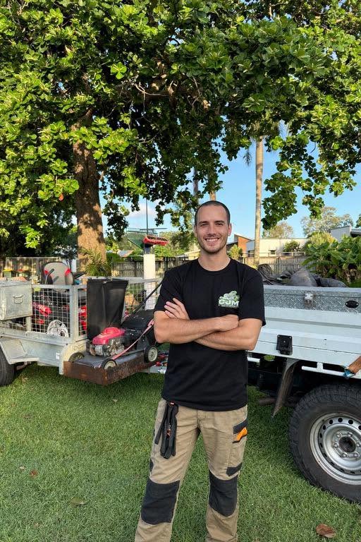 Isaac from CJM Lawn Care standing in front of the work ute and mower trailer
